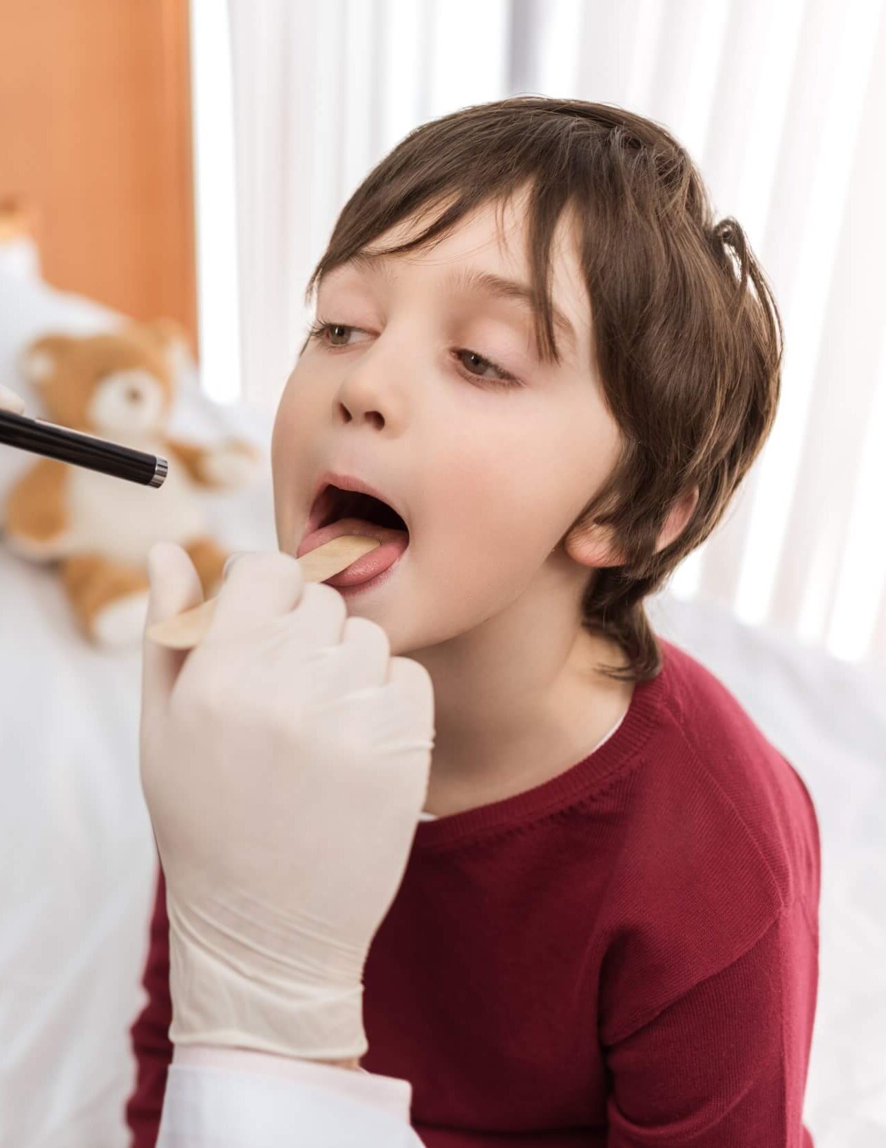 man-doctor-examining-throat-of-little-boy-in-hospi-2021-09-03-16-51-18-utc-e1644252180701.jpg